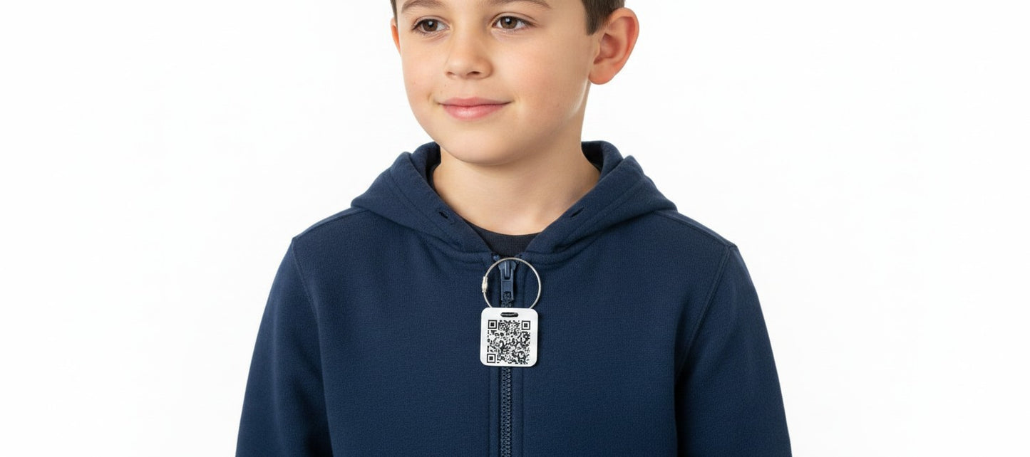 Speak For Me Systems square QR code tag attached to a child's navy blue hoodie zipper