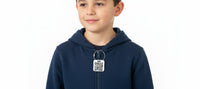 Speak For Me Systems square QR code tag attached to a child's navy blue hoodie zipper