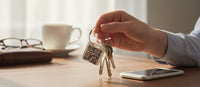 Speak For Me Systems SQUARE TAG keychain with QR code held by a hand with keys on a wooden desk